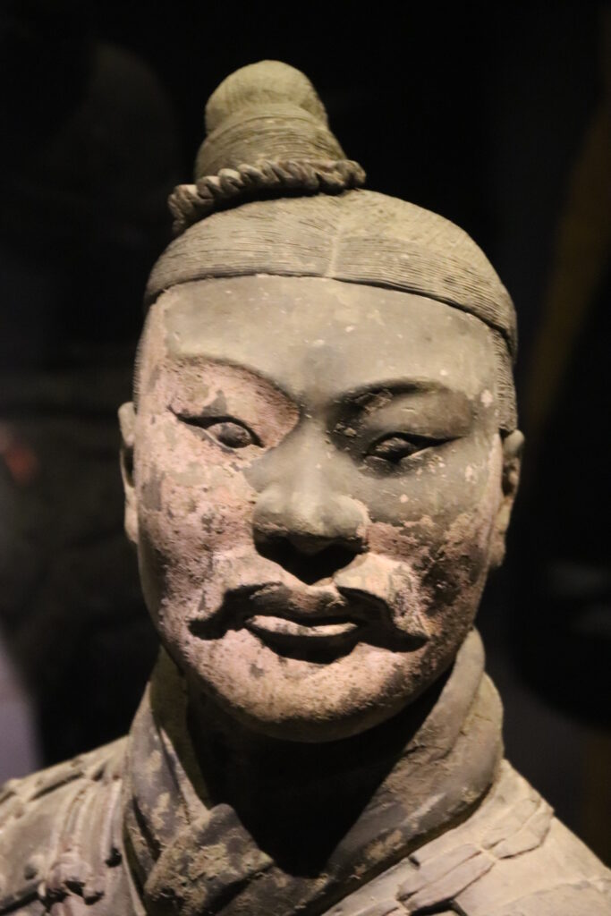 Close view of a terracotta kneeling archer head and topknot