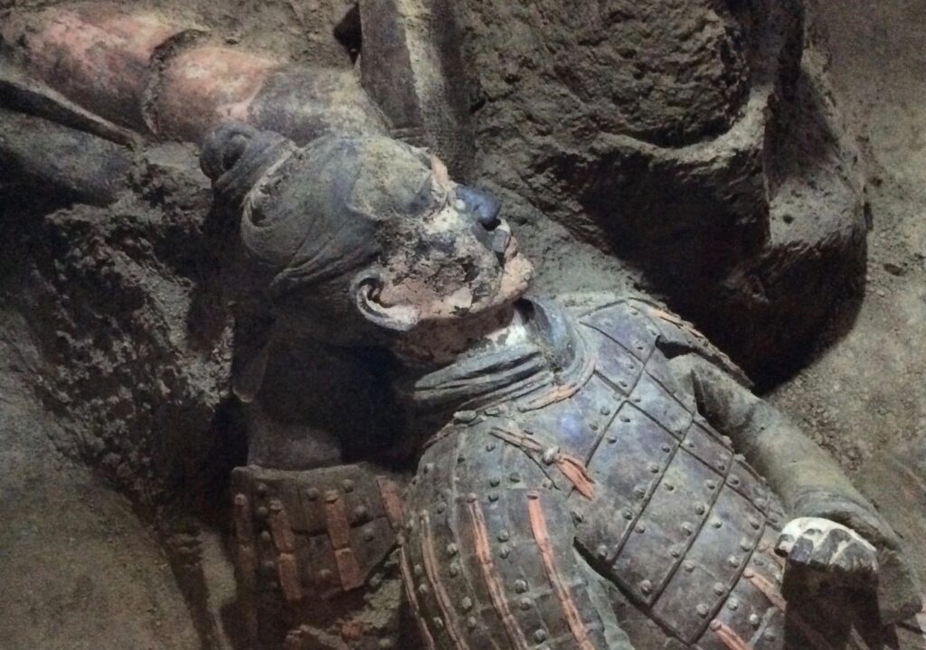 Terracotta warrior with traces of colour at the excavation site