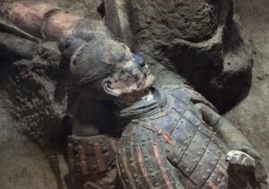 Terracotta warrior with traces of colour at the excavation site