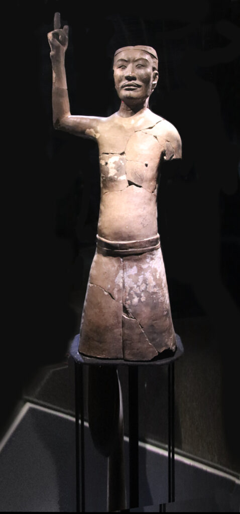 Terracotta acrobat figure from Pit K9901 with a raised arm
