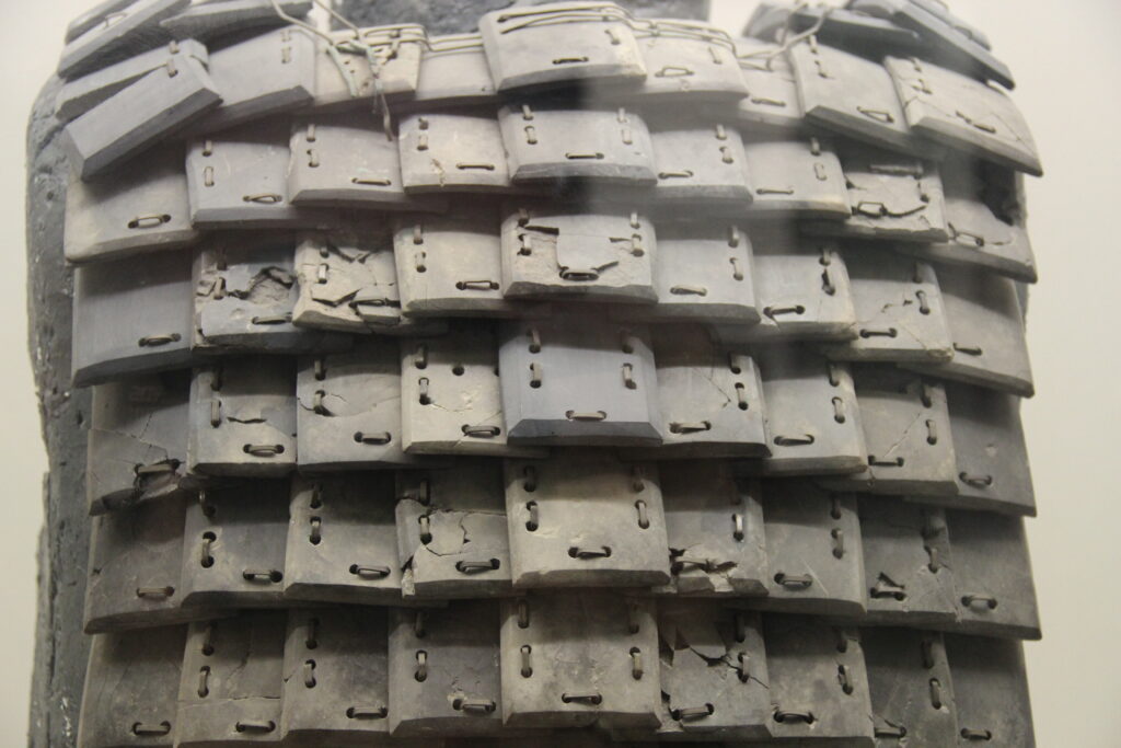 Close view of drilled limestone armor plates and connecting wire