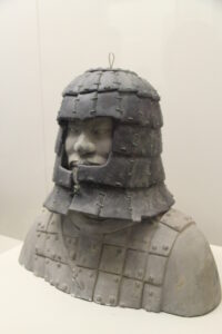 Stone helmet assembled on a museum display bust