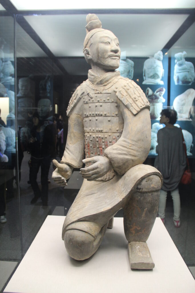 Terracotta Army kneeling archer with a tall hair knot, armor, and bent-knee posture