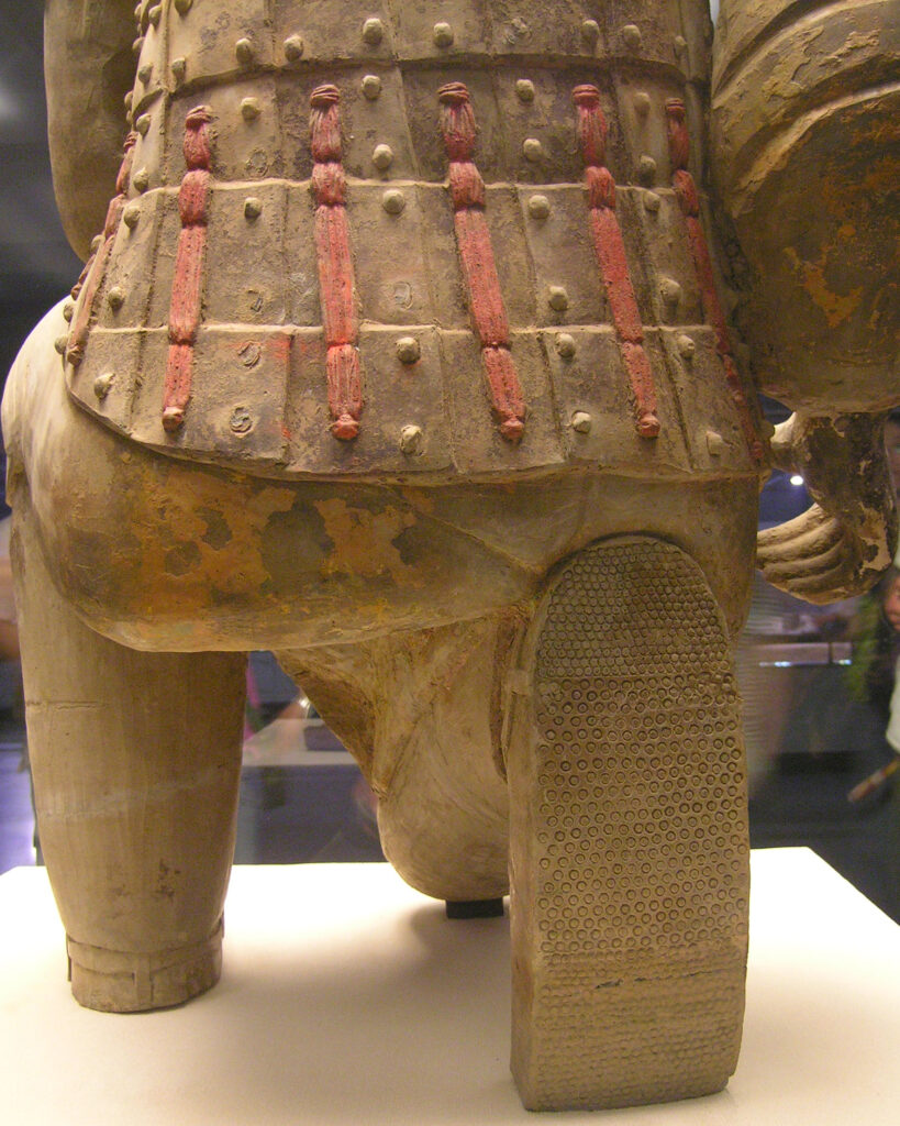 Rear detail of a kneeling archer showing modeled armor ties and a patterned shoe sole
